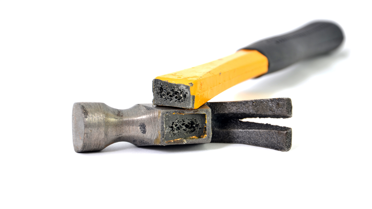 Ein defekter Hammer mit einem gelben und einem schwarzen Griff